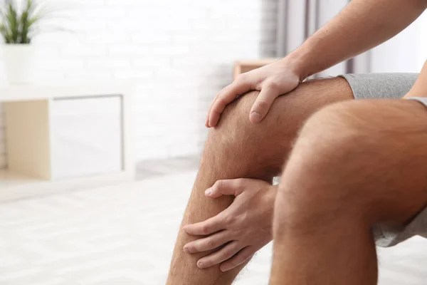 Man die lijden aan pijn in het been thuis, close-up. Ruimte voor tekst — Stockfoto