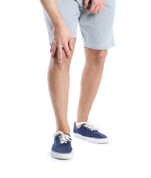 Homem que sofre de dor nas pernas no fundo branco, close-up — Fotografia de Stock