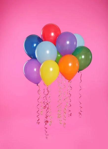 Många ljusa ballonger flyter på färg bakgrunden — Stockfoto