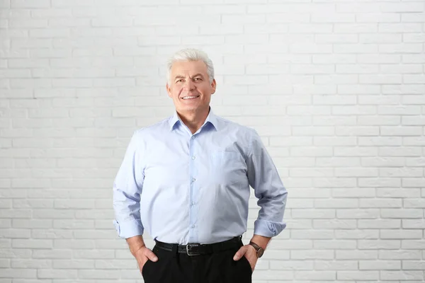 Portrait d'un bel homme mature près d'un mur de briques — Photo