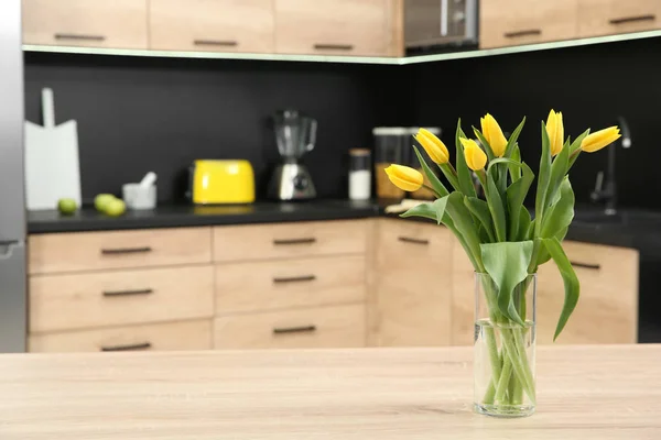 Glasvase mit Tulpen auf dem Tisch in der Küche — Stockfoto