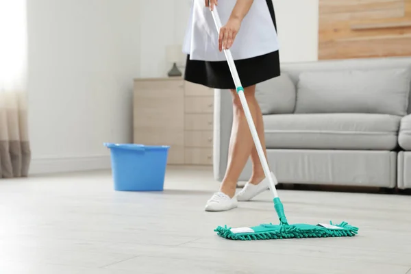 Młoda pokojówka mycie podłogi z mopem w pokoju hotelowym, zbliżenie — Zdjęcie stockowe