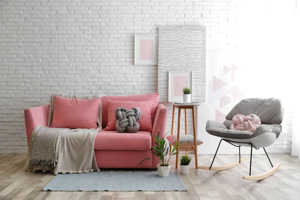 Stilvolles Wohnzimmerinterieur mit Sofa und Schaukelsessel in der Nähe der Ziegelwand. Raum für Text — Stockfoto