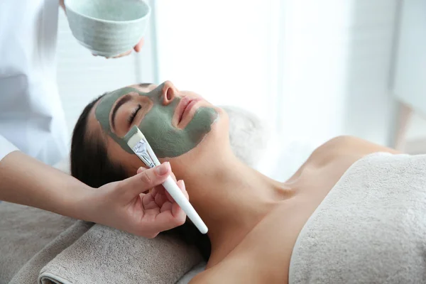 Kosmetologis menerapkan topeng pada wajah klien di spa salon — Stok Foto