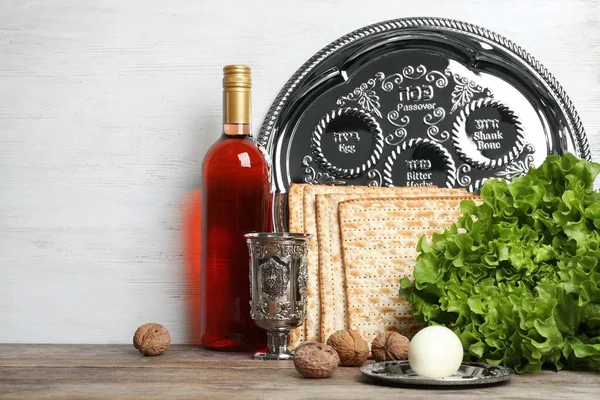 Symbolic Passover (Pesach) items on table against wooden background, space for text — Stock Photo, Image
