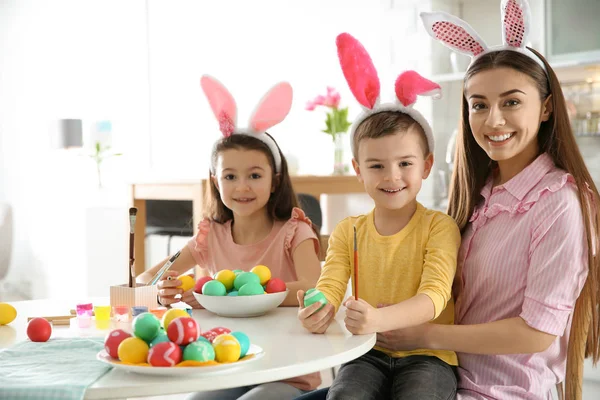 Anne ve çocukları Paskalya yumurtaları mutfak, metin için yer boyama tavşan kulakları saç bantları ile — Stok fotoğraf