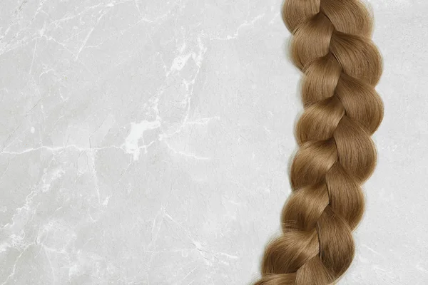 Πλεκτά μαλλιά σε γκρίζο φόντο, το top view με χώρο για κείμενο — Φωτογραφία Αρχείου