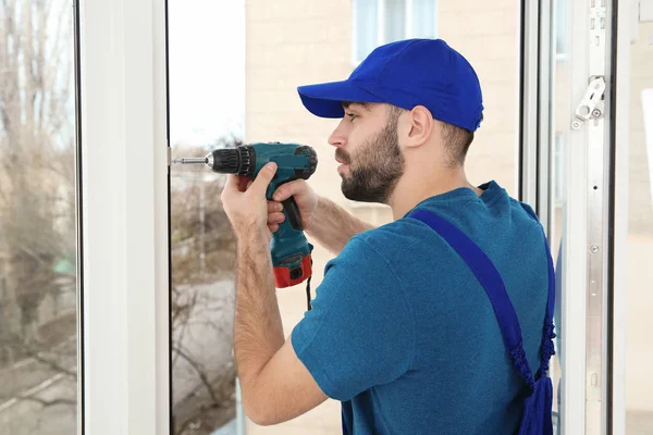 Bauarbeiter mit Bohrer beim Einbau von Fenstern im Haus — Stockfoto