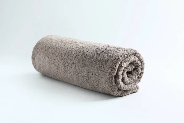 Färsk fluffig rullad handduk på grå bakgrund — Stockfoto