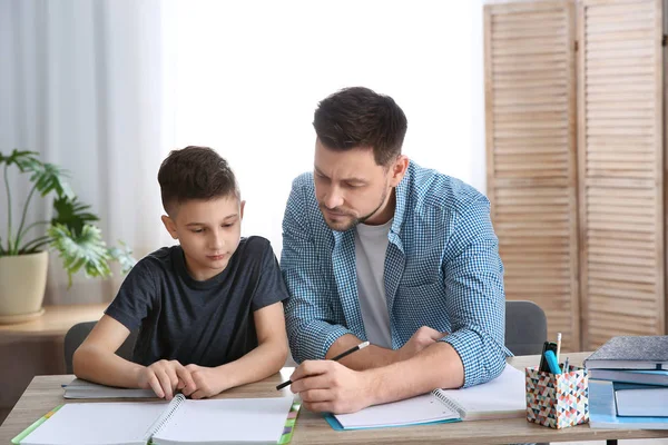 Papá ayudando a su hijo con la tarea en la habitación — Foto de Stock