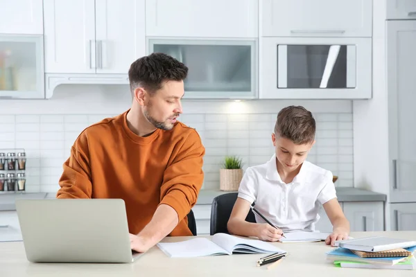 Papá ayudando a su hijo con la tarea en la cocina — Foto de Stock