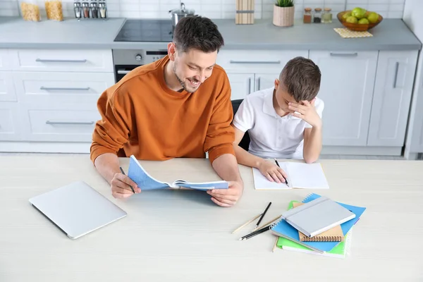 Papá ayudando a su hijo con la tarea en la cocina, vista superior — Foto de Stock
