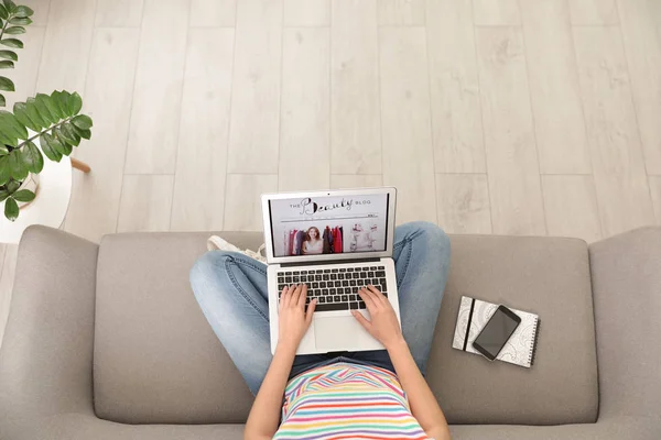 Mulher segurando laptop com site blogger beleza aberta no sofá, acima vista — Fotografia de Stock