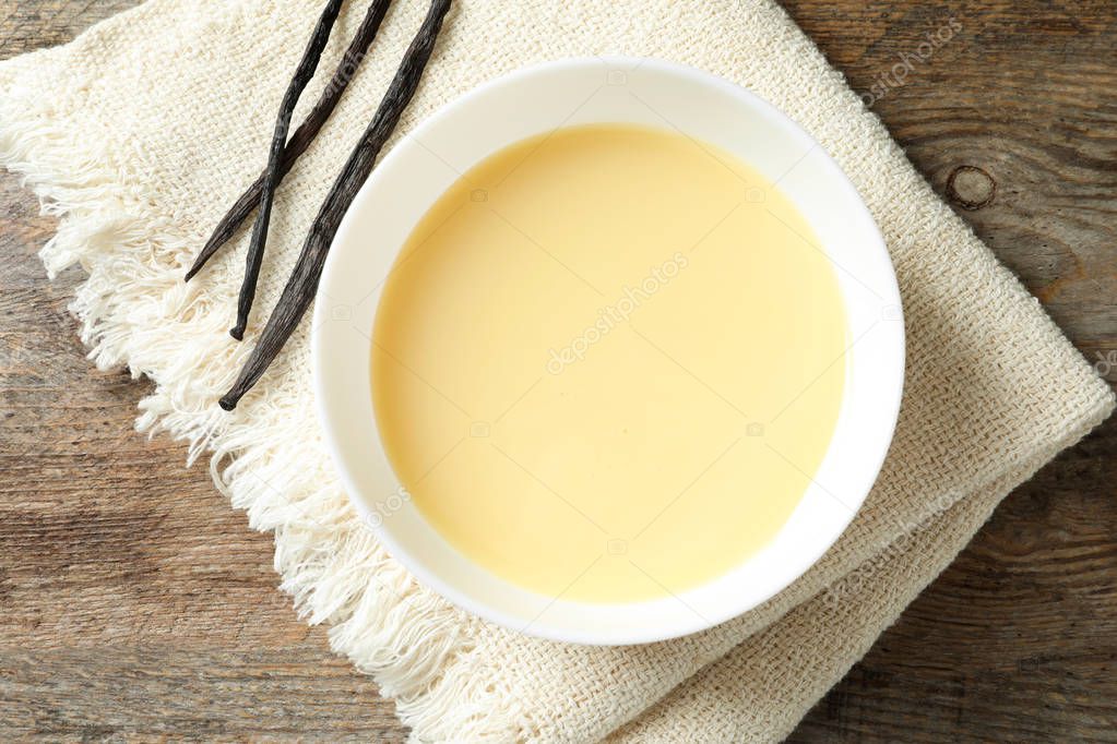 Bowl with condensed milk served on table, top view. Dairy products