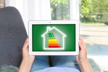 Enerji verimliliği ekranında, closeup simgesiyle tablet kullanan kadın