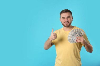 Renk arka plan üzerinde para ile mutlu genç adam portresi. Metin için yer
