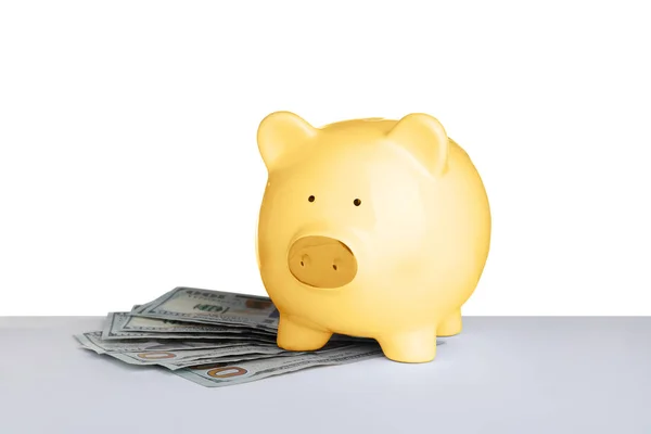 Gold piggy bank with money on table against white background — Stock Photo, Image