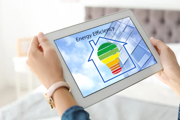 Mulher usando tablet com ícone de eficiência energética na tela, close-up — Fotografia de Stock