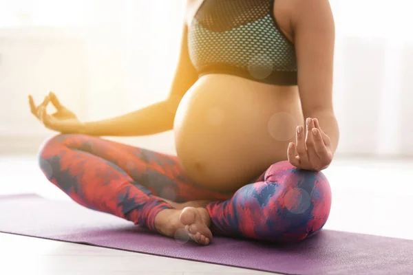 Mujer embarazada joven practicando yoga zen en interiores, primer plano —  Fotos de Stock