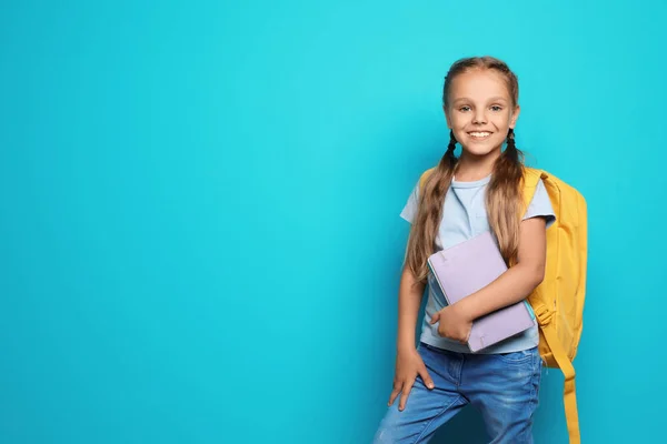 Petit écolier avec sac à dos et copybook sur fond de couleur — Photo