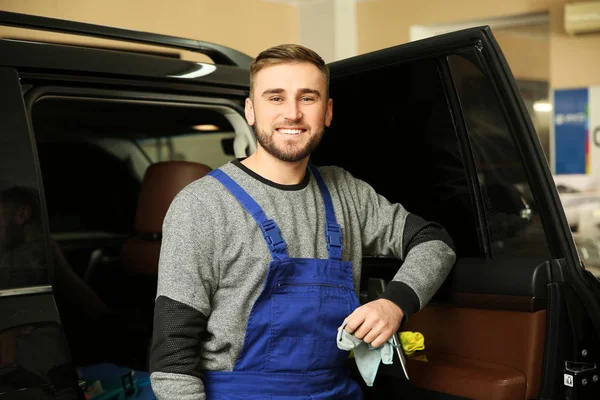 Trabajador sonriente parado cerca del coche en la tienda. Servicio de teñido de ventanas —  Fotos de Stock