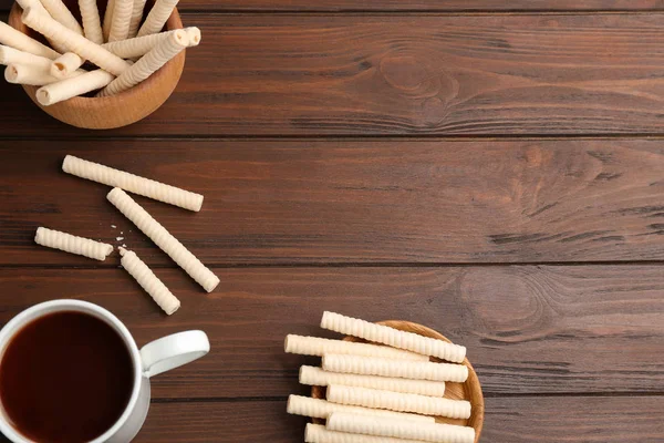 Composición plana con rollos de oblea y taza de cacao sobre fondo de madera, espacio para texto —  Fotos de Stock