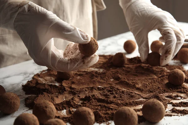 Kadın masada, closeup lezzetli çikolata truffles hazırlanması — Stok fotoğraf