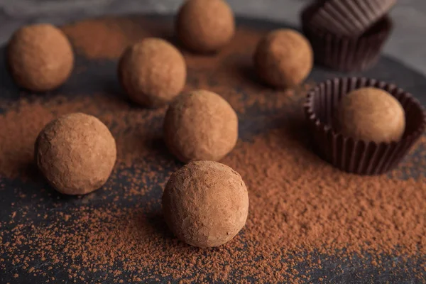 Chocolate truffles powdered with cocoa on slate plate, closeup