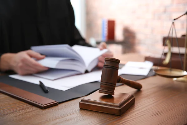 Судья работает за столом в офисе, сосредоточившись на молотке. Закон и справедливость — стоковое фото