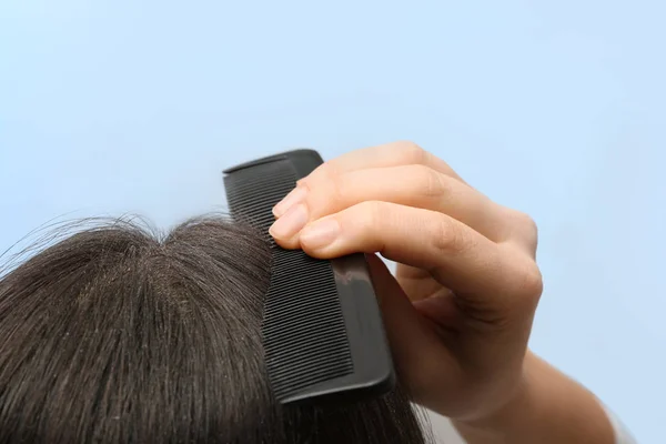 Mulher com pente e caspa em seu cabelo escuro no fundo de cor, close-up — Fotografia de Stock