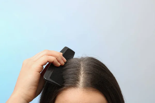 Mulher com pente e caspa em seu cabelo escuro no fundo de cor, close-up. Espaço para texto — Fotografia de Stock