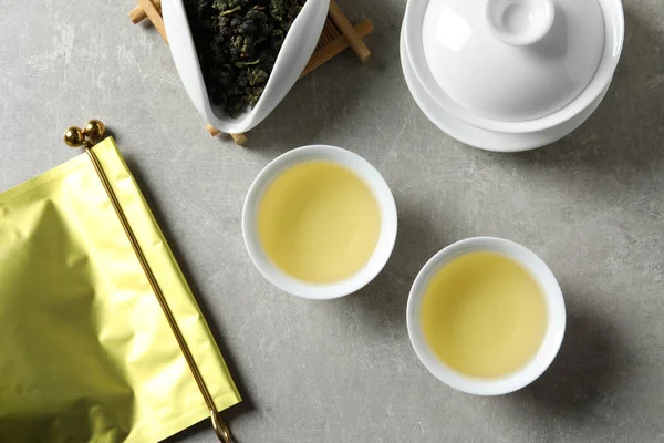 Плоская композиция с чашками чая Tie Guan Yin oolong на сером фоне — стоковое фото