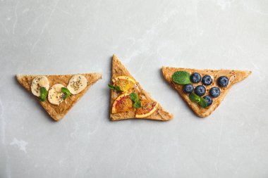 Meyve, yaban mersini, fıstık ezmesi ve gri arka plan üzerinde chia tohum ile farklı tost görünümü top