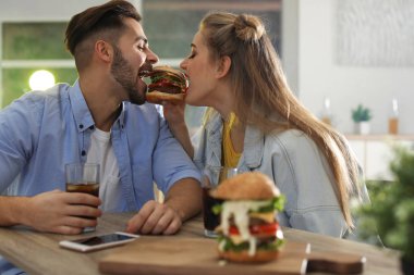 Mutlu genç çift burger restoranda öğle yemeği