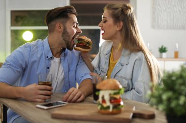 Mutlu genç çift burger restoranda öğle yemeği