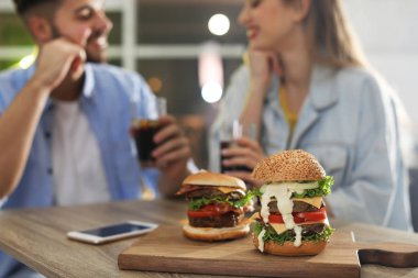 Genç çift restoranda hamburger ile gemide odak Öğle Yemeği