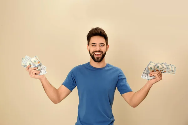 Retrato de joven feliz con dinero en el fondo de color —  Fotos de Stock