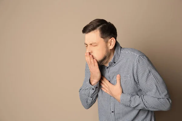 Hombre que sufre de tos en el fondo de color. Espacio para texto —  Fotos de Stock