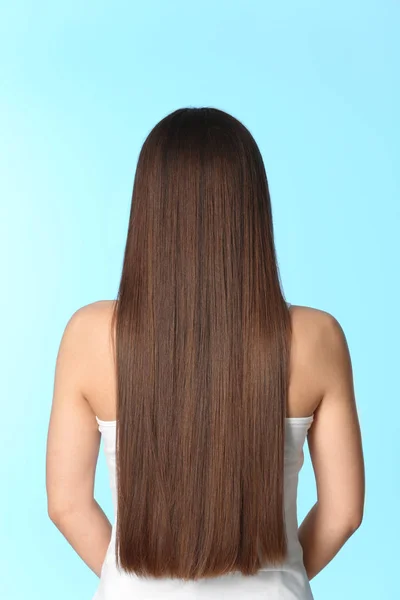 Mujer con cabello castaño largo sobre fondo de color — Foto de Stock