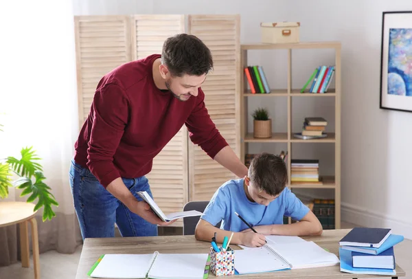 Papá ayudando a su hijo con la tarea en la habitación — Foto de Stock