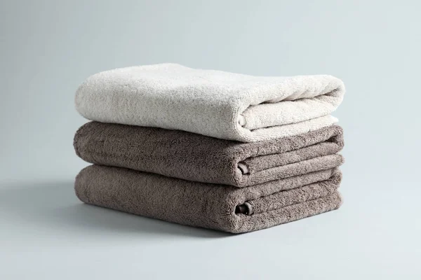 Pilha de toalhas macias frescas em fundo cinza — Fotografia de Stock
