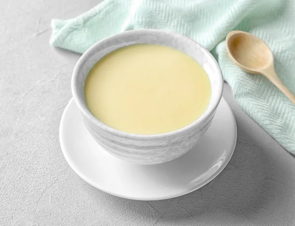 Bowl with condensed milk served on table. Dairy products