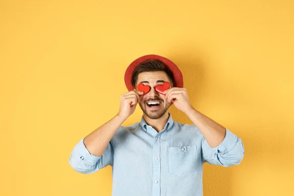 Homme tenant des cœurs décoratifs sur fond de couleur — Photo