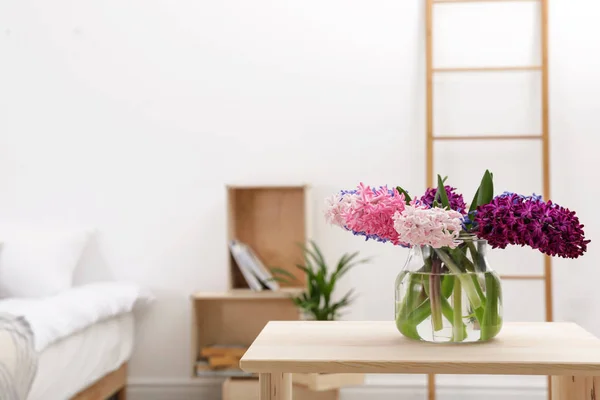 Belas jacintos em vaso de vidro na mesa dentro de casa, espaço para texto. Flores de primavera — Fotografia de Stock
