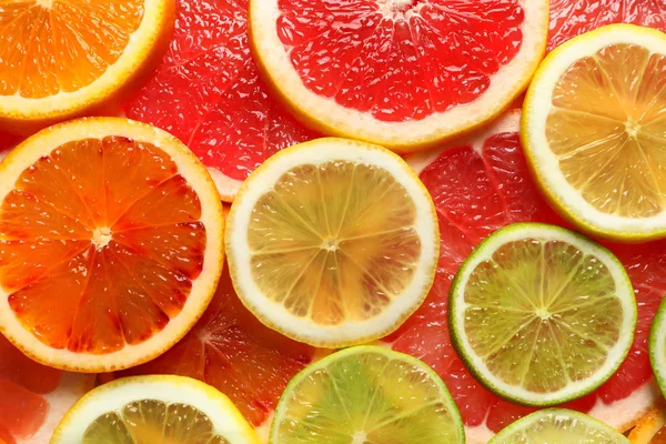 Plastrami świeżych owoców cytrusowych, jako tło, widok z góry — Zdjęcie stockowe