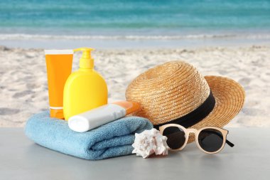 Güneş koruma vücut kremi ve plaj aksesuarları farklı şişe ile deniz manzarası karşı tablo ayarlama. Alan tasarımı için