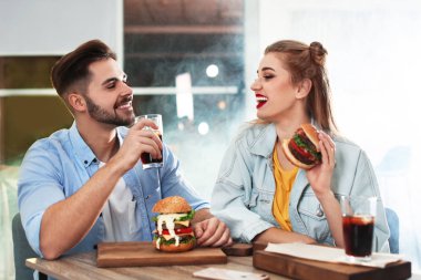 Mutlu genç çift burger restoranda öğle yemeği