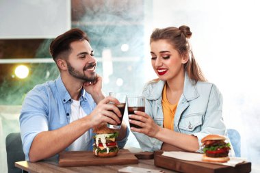 Mutlu genç çift burger restoranda öğle yemeği