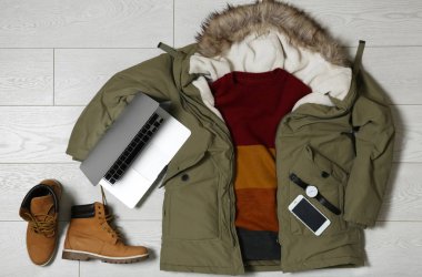 Sıcak giysiler ayarla ve ahşap arka plan, düz cihazlarda yatıyordu. Kış tatili