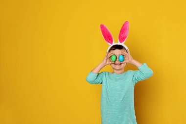 Tavşan kulaklar kafa bandı Paskalya yumurtaları gözler yakın renk arka plan, metin için yer tutan çocuğu